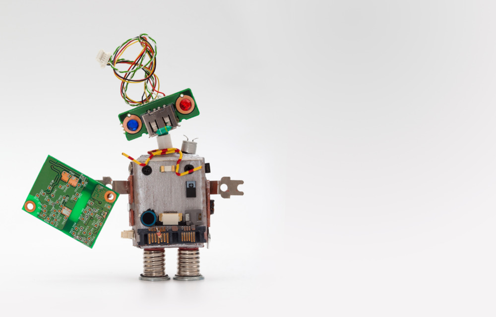 ALT: A small robot made of electronic parts holding a circuit board, symbolizing technical challenges after the MTEP dissolution.